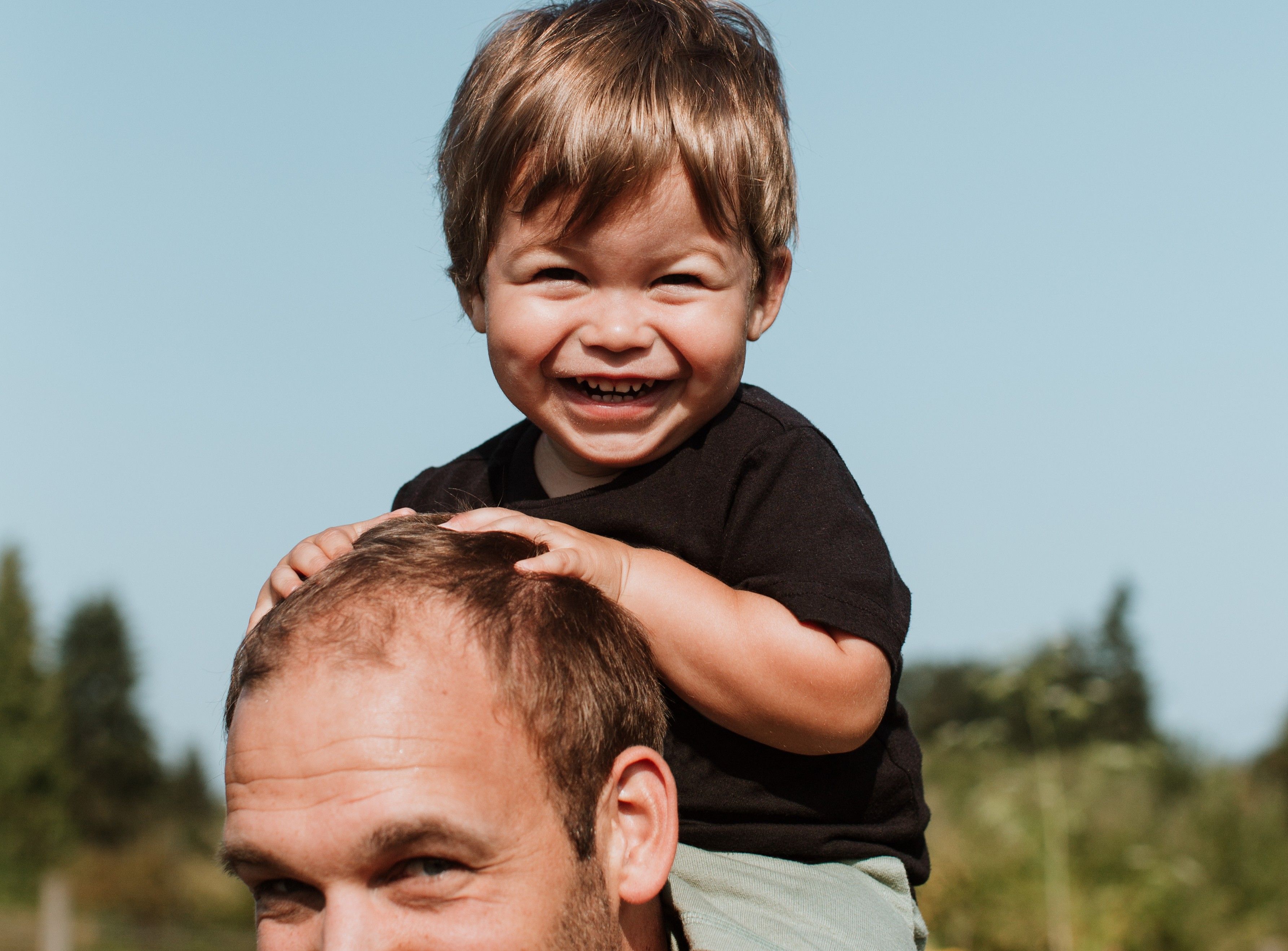 Boy Smiling on Dad's Shoulders