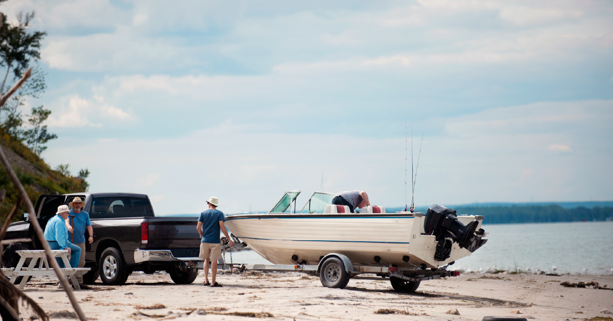 Truck towing boat on beach